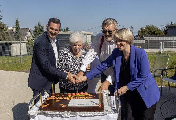 Der Bezirksvorsteher von Favoriten, Marcus Franz, eine Kundin des Tageszentrums, Stadtrat Peter Hacker und FSW-Geschäftsführerin Susanne Winkler schneiden bei der Standorteröffnung eine Torte an.