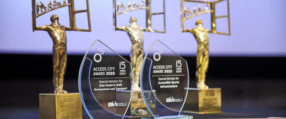 Drei aneinander gereihte Access City Awards - Trophäen.