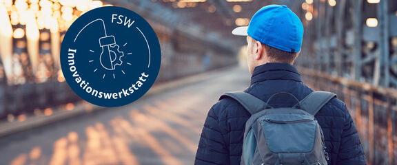 FSW-Innovationswerkstatt | iStock / Chalabala Ein junger Mann mit Rucksack und blauer Mütze von hinten auf einer Brücke.